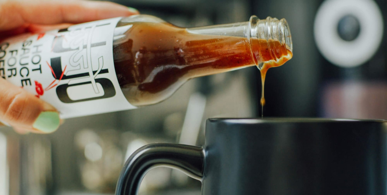 Woman pouring Ujjo sauce into black cup