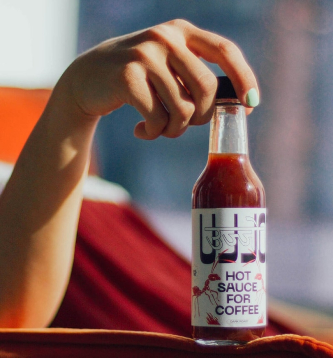 Woman's hand holding a bottle of Ujjo sauce